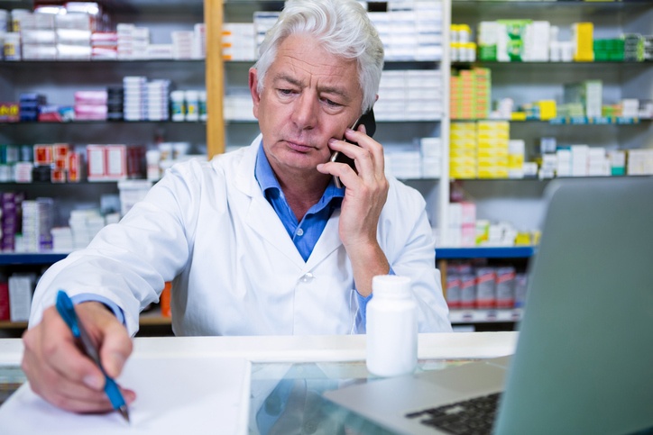 Pharmacist talking on mobile phone about prescriptions using HIPAA compliant softphone application